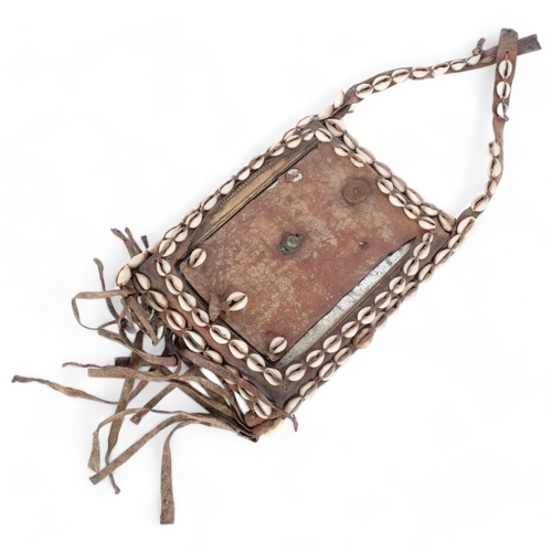 43 - An African Tribal chest plate, with inset mirror decorated with cowrie shells, approx 25cm x 19cm