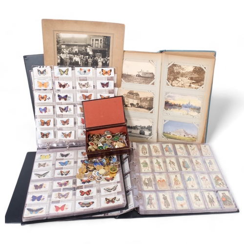 95 - 2 albums of cigarette cards, a Vintage postcard and photograph album, and a tin of Bowls badges