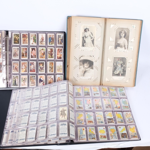 95 - 2 albums of cigarette cards, a Vintage postcard and photograph album, and a tin of Bowls badges