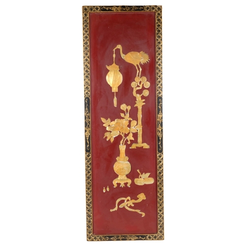 948 - A Chinese rectangular red and black lacquered panel with applied decoration, 92cm x 31cm