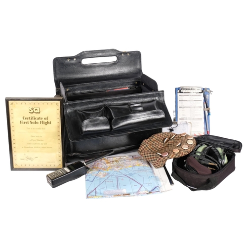 956 - A pilot's leather flight bag and contents, including manuals, radio, headphones etc, a framed certif... 