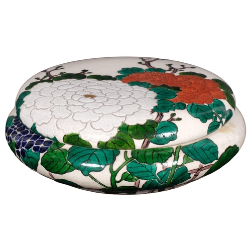 983 - In the manner of Ninsei, a Japanese crackle glaze circular box and cover, hand painted red green and... 