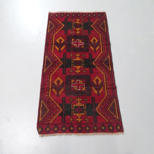 2305 - A red ground Baluchi rug, 137x70cm.