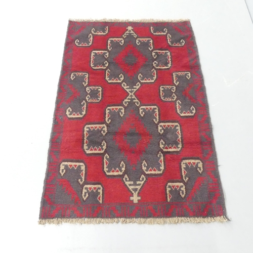 2316 - A red-ground Baluchi rug. 135x90cm.