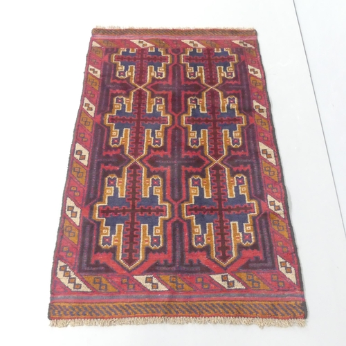 2320 - A red-ground Baluchi rug. 135x84cm.