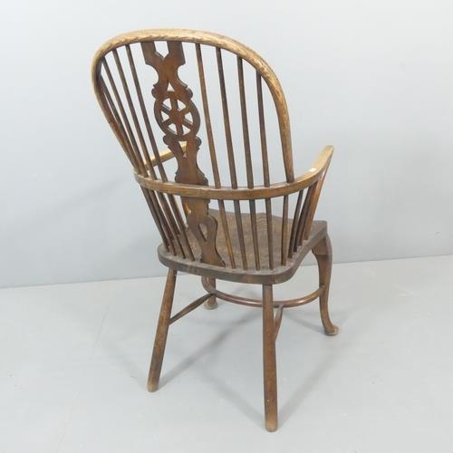 2273 - An elm-seated Windsor elbow chair, with wheelback and crinoline stretcher.