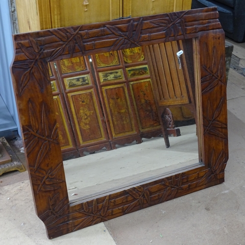 2370 - A mahogany framed wall mirror with carved bamboo leaf decoration. 81x72cm.