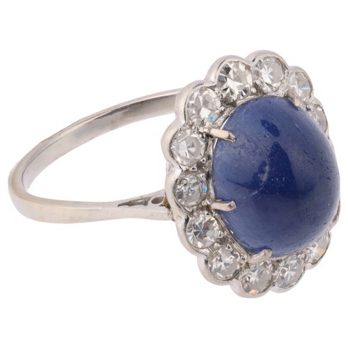 33 - A Sapphire and Diamond Cluster Ring,

set with an oval cabochon sapphire of approximately 5.40 carat... 