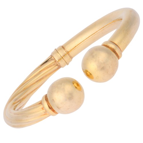 32 - UNOAERRE - A Vintage Gold Bangle,

each half of polished and twisted tubular form with a ball termin... 