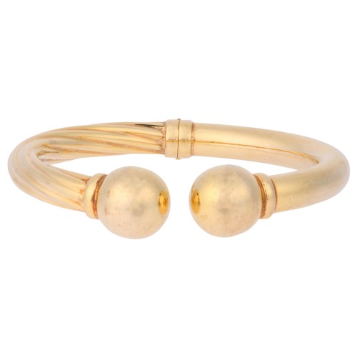 32 - UNOAERRE - A Vintage Gold Bangle,

each half of polished and twisted tubular form with a ball termin... 