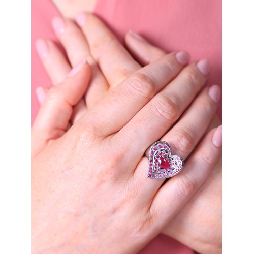 47 - NOURBEL - A Ruby Heart Ring,

set with a central heart cut ruby surrounded by two rows of round cut ... 