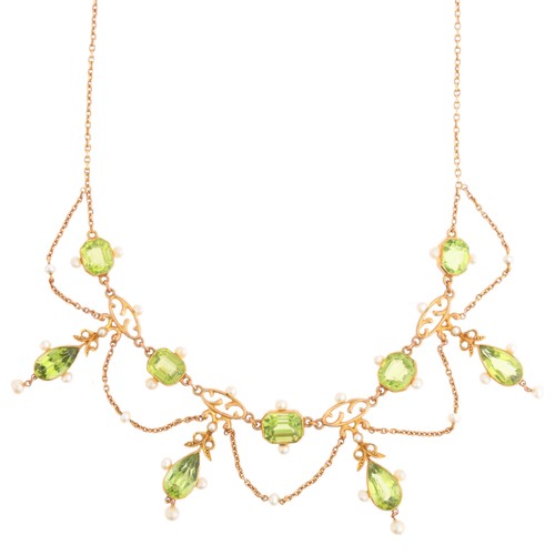 61 - An Antique Edwardian Peridot and Pearl Festoon Necklace,

circa 1905, set with pear cut peridot flor... 