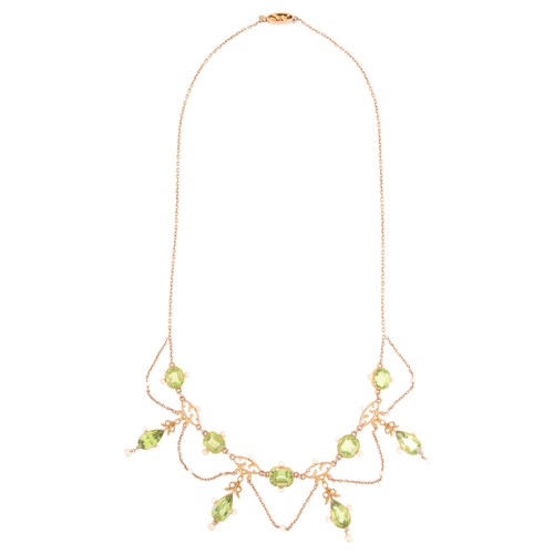 61 - An Antique Edwardian Peridot and Pearl Festoon Necklace,

circa 1905, set with pear cut peridot flor... 