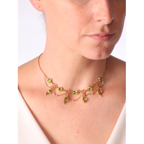 61 - An Antique Edwardian Peridot and Pearl Festoon Necklace,

circa 1905, set with pear cut peridot flor... 