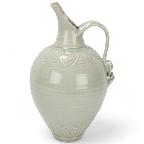 68 - BRIDGET DRAKEFORD (b.1946), a celadon glaze, studio pottery porcelain jug, with banded sgraffito dec... 