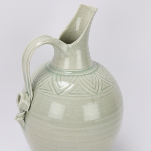 68 - BRIDGET DRAKEFORD (b.1946), a celadon glaze, studio pottery porcelain jug, with banded sgraffito dec... 