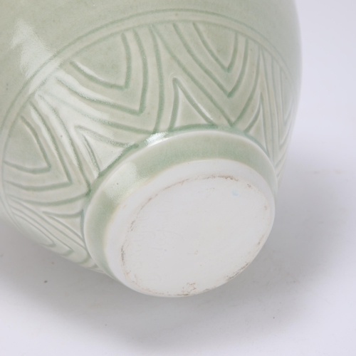 68 - BRIDGET DRAKEFORD (b.1946), a celadon glaze, studio pottery porcelain jug, with banded sgraffito dec... 