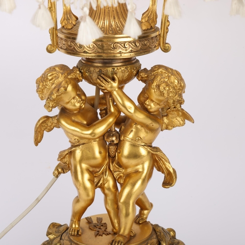 321 - An ornate French gilt-bronze table lamp, supported by 2 cherubs, probably late 19th century, on ormo... 