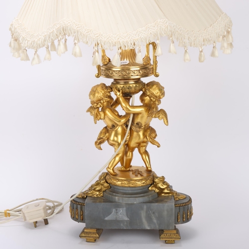 321 - An ornate French gilt-bronze table lamp, supported by 2 cherubs, probably late 19th century, on ormo... 