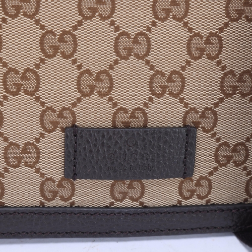 418 - A Gucci medium sized crossbody messenger bag, monogram fabric and dark brown leather trim, with Gucc... 