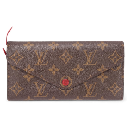 419 - A Louis Vuitton Sarah wallet, in brown monogram leather, with red leather covered leather and interi... 