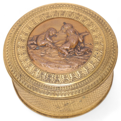 523 - A French 19th century circular gilt-bronze box, with relief decorated lid and mirror inside, diamete... 