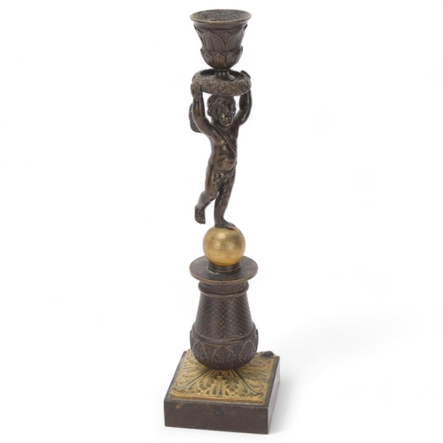 539 - A 19th century parcel-gilt bronze candlestick, supported by a cherub, height 32cm