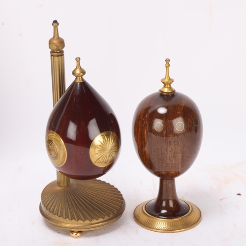 540 - Theo Faberge, 2 ornamental eggs, specimen wood and brass, largest height 14cm, together with a book