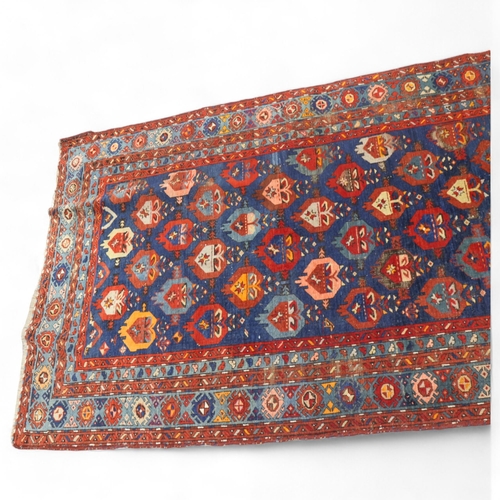 369 - An Antique Caucasian wool rug, blue/red ground, 148cm x 261cm