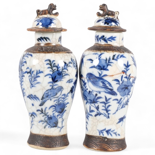 561 - A pair of Chinese blue and white jars and covers, with dog of fo knop and bird decoration, character... 