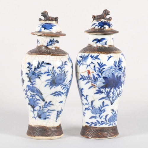 561 - A pair of Chinese blue and white jars and covers, with dog of fo knop and bird decoration, character... 