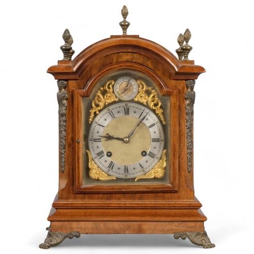 566 - A walnut breakarch 8-day bracket clock with brass mounts and paw feet, two train German movement str... 