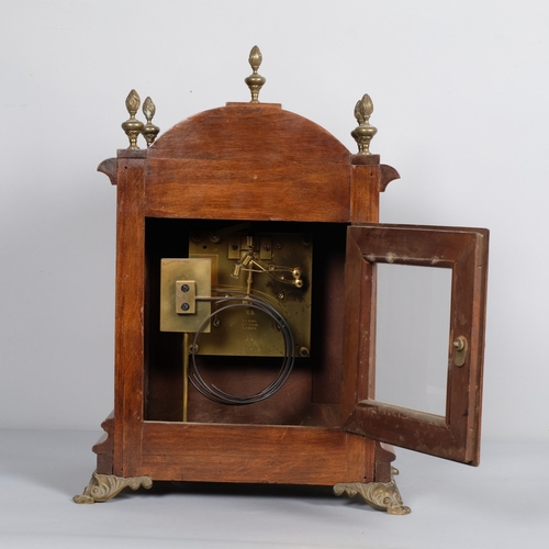 566 - A walnut breakarch 8-day bracket clock with brass mounts and paw feet, two train German movement str... 