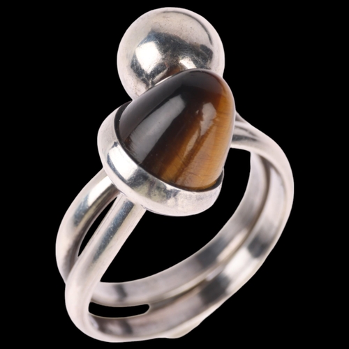 1359 - NIELS ERIK FROM - a Danish modernist sterling silver tigers eye crossover ring, setting height 16.5m... 