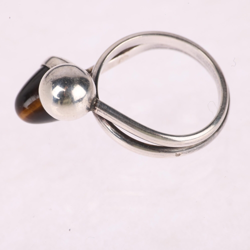 1359 - NIELS ERIK FROM - a Danish modernist sterling silver tigers eye crossover ring, setting height 16.5m... 