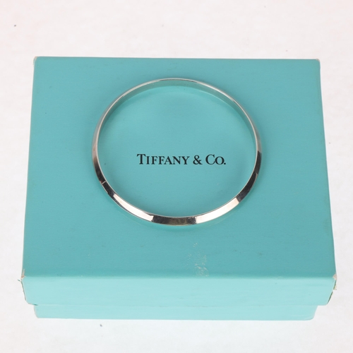 1434 - TIFFANY & CO - a sterling silver bangle, maker T&Co, import London 1995, band width 4.8mm, internal ... 