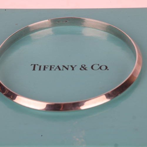 1434 - TIFFANY & CO - a sterling silver bangle, maker T&Co, import London 1995, band width 4.8mm, internal ... 