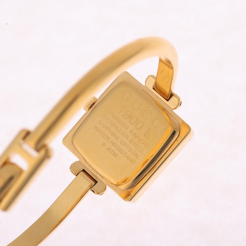 1027 - GUCCI - a lady's gold plated stainless steel 1900L quartz bangle watch, champagne dial with leaf han... 