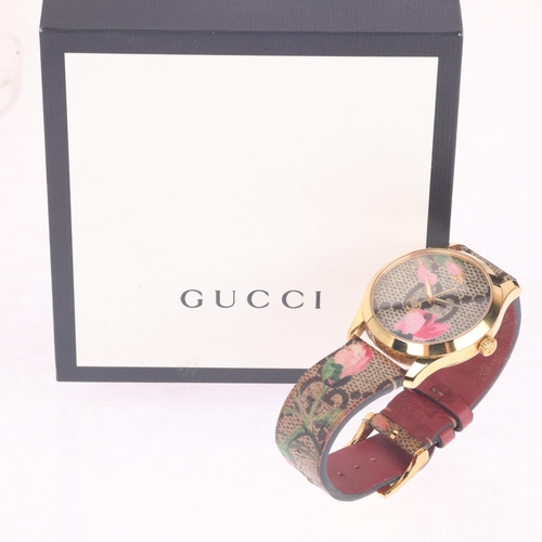 1034 - GUCCI - a lady's gold plated stainless steel G-Timeless 'Pink Blooms' quartz wristwatch, ref. 126.4,... 