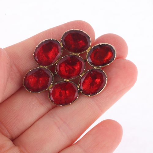 1109 - A Georgian flat-top red paste cluster mourning brooch, circa 1820, cut-down collet set with foil-bac... 