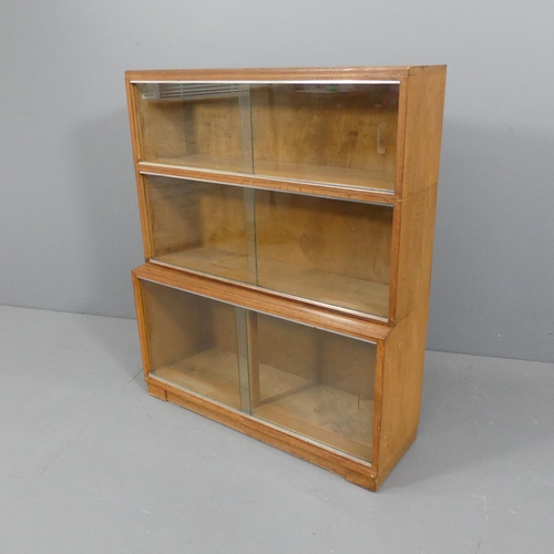 2105 - MINTY - A mid-century oak three shelf sectional stacking bookcase with sliding glazed doors and make... 