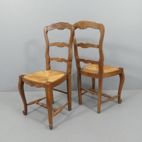 2108 - A set of six French oak rush-seated ladder-back dining chairs.