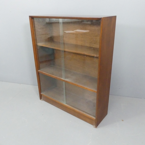 2190 - HERBERT GIBBS - A mid-century teak bookcase, with glass sliding doors and maker's label. 92x112x28cm... 