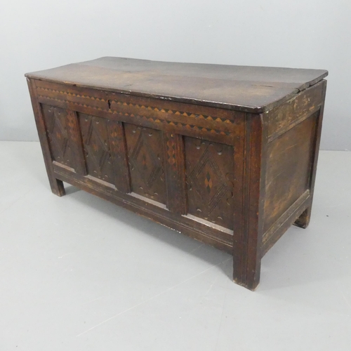 2207 - An 18th century panelled oak coffer, with carved and inlaid decoration. 130x66x53cm.