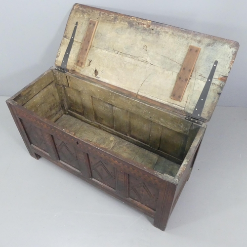 2207 - An 18th century panelled oak coffer, with carved and inlaid decoration. 130x66x53cm.