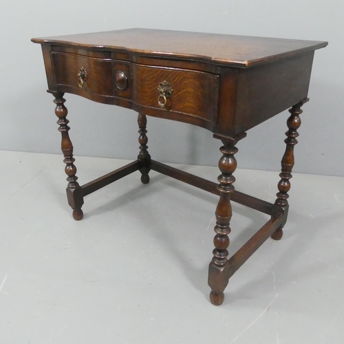 2219 - J A S SHOOLBRED - A Victorian oak serpentine fronted writing table, with turned legs and single draw... 