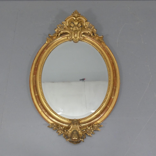 2270 - A modern continental style oval wall mirror with applied decoration. 74x112cm.