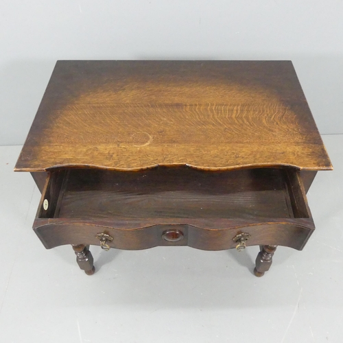 2219 - J A S SHOOLBRED - A Victorian oak serpentine fronted writing table, with turned legs and single draw... 