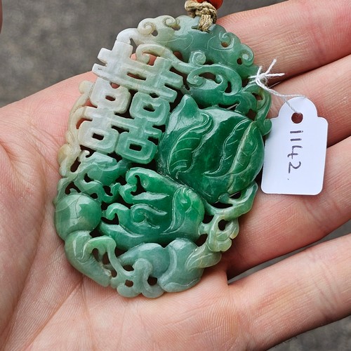 1142 - A Chinese carved jade 'Double Happiness' amulet pendant, carved and pierced depicting peach and blos... 