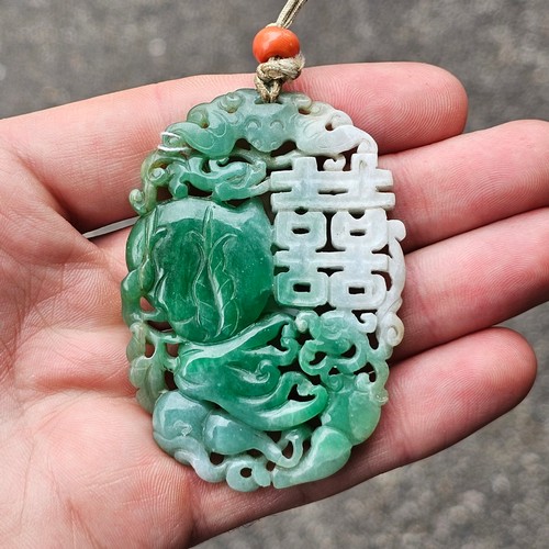 1142 - A Chinese carved jade 'Double Happiness' amulet pendant, carved and pierced depicting peach and blos... 